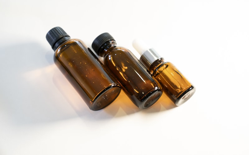 Three amber glass massage oil bottles on a white surface