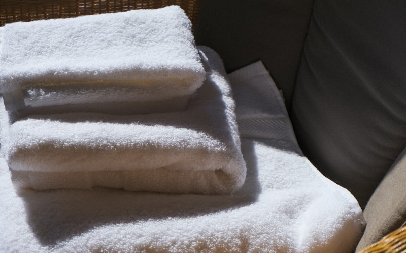 A stack of clean folded white towels in soft daylight